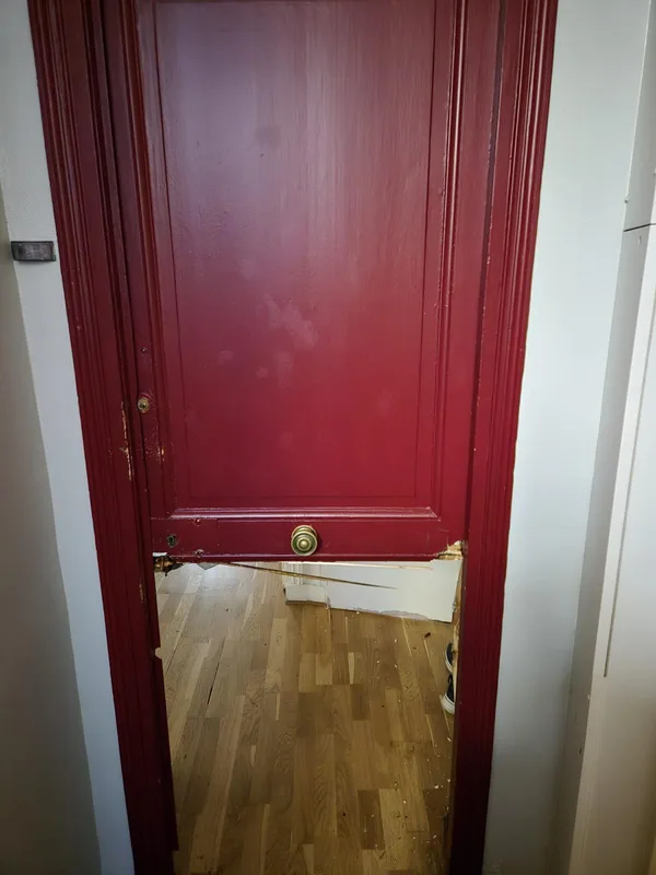 Porte d'entrée rouge au panneau inférieur fracturé